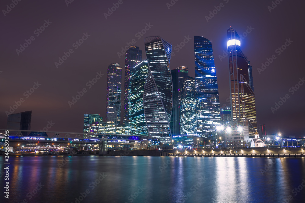 Moscow city night view with skyscrapers and a futuristic bridge over the river