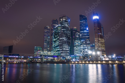 Moscow city night view with skyscrapers and a futuristic bridge over the river © Dmitrii