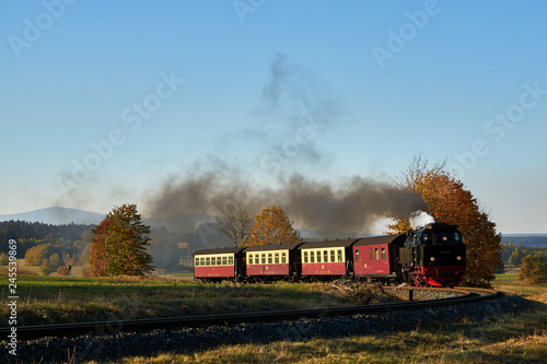 Harzer Schmalspurbahn unter Dampf im Hintergrund eine Herbdtlandschaft und der Brocken photo