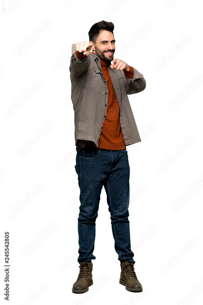 Full-length shot of Handsome man with beard points finger at you while smiling on isolated white background Full-length shot of Handsome man with beard points finger at you while smiling on isolated white background