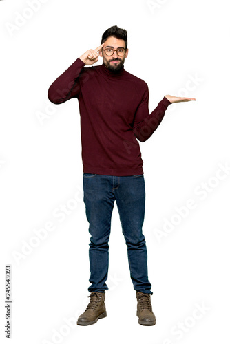 Full-length shot of Handsome man with glasses making the gesture of madness putting finger on the head on isolated white background