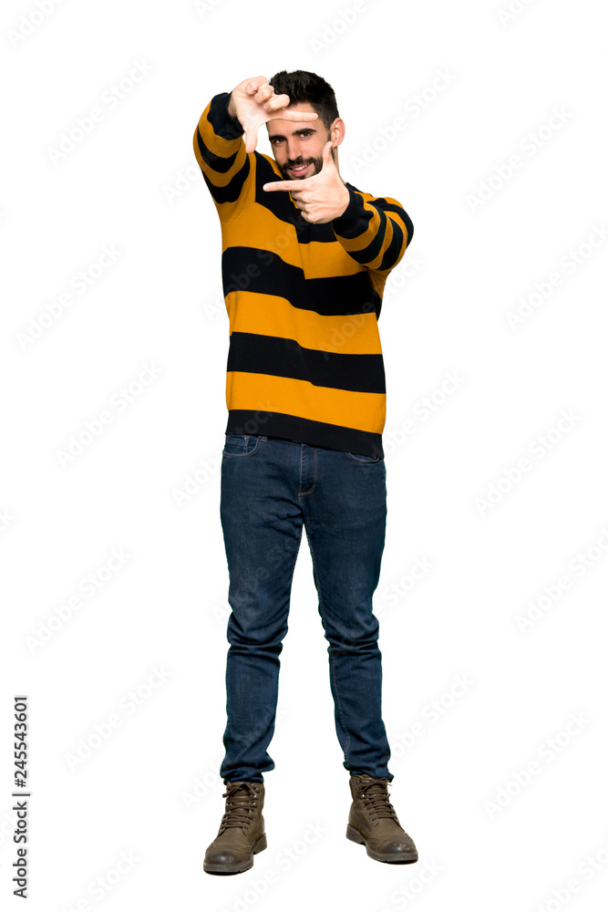 Full-length shot of Handsome man with striped sweater focusing face. Framing symbol on isolated white background Full-length shot of Handsome man with striped sweater focusing face. Framing symbol on isolated white background