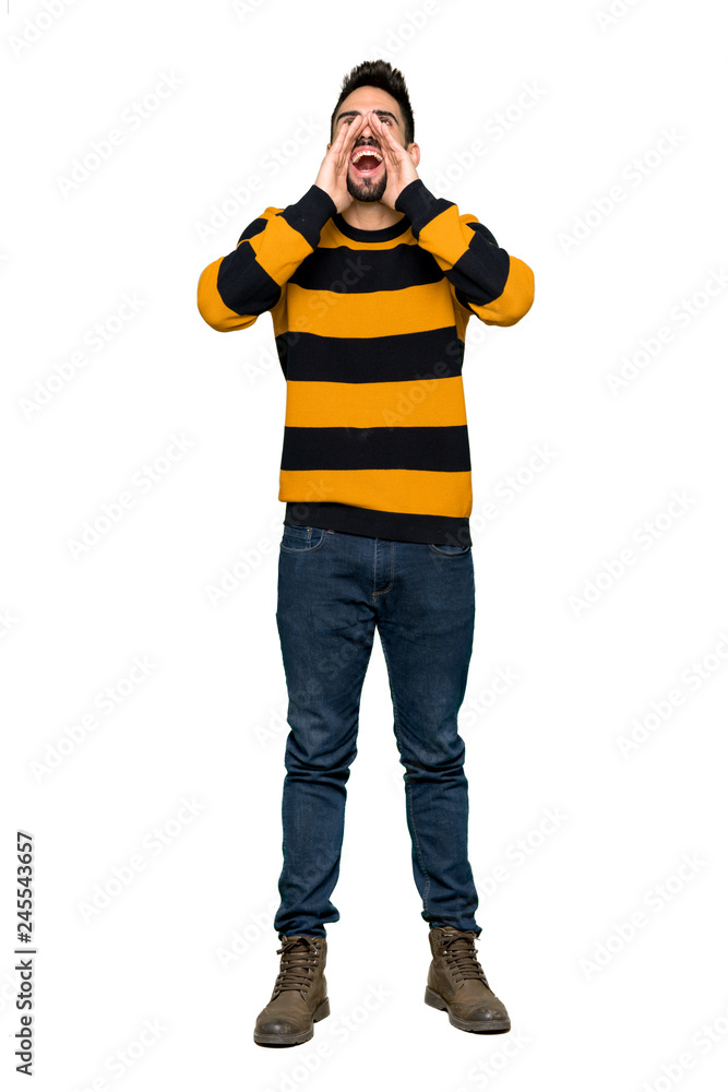 Full-length shot of Handsome man with striped sweater shouting and announcing something on isolated white background Full-length shot of Handsome man with striped sweater shouting and announcing something on isolated white background