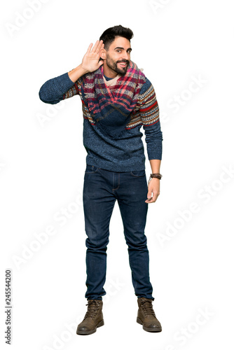 Full-length shot of Hippie man listening to something by putting hand on the ear on isolated white background