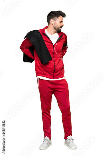 Full-length shot of Handsome sportman suffering from backache for having made an effort on isolated white background