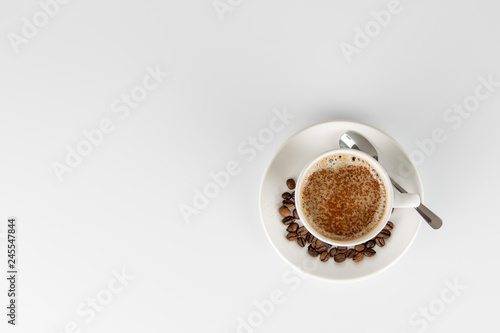 Cup of coffee with cocoa powder forming a heart on the foam