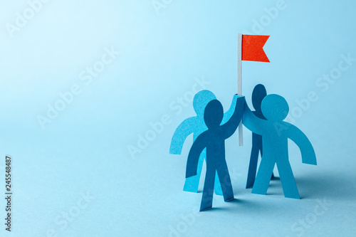 Business team and red flag with goal. The team seeks to achieve the goal. Copy space for text.