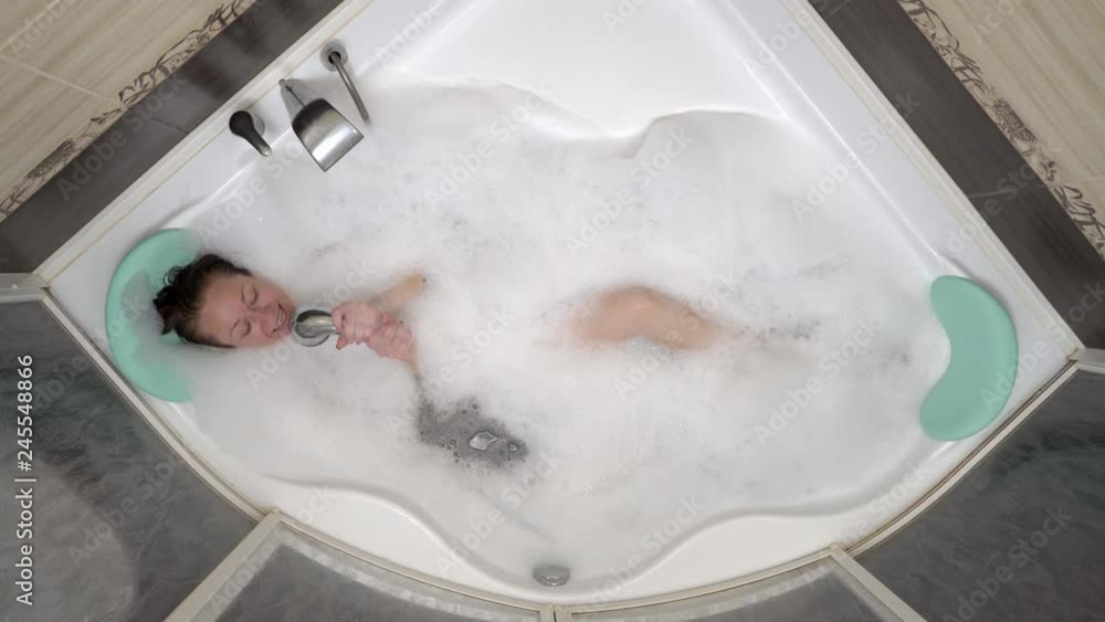 beautiful woman lies in bath with foam and sings a song.
beautiful woman lies in bath with foam and sings a song.