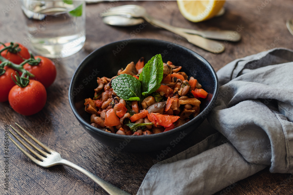 Fototapeta premium Vegetable Stew with Beans, Mushrooms and Tomatoes on a wooden background