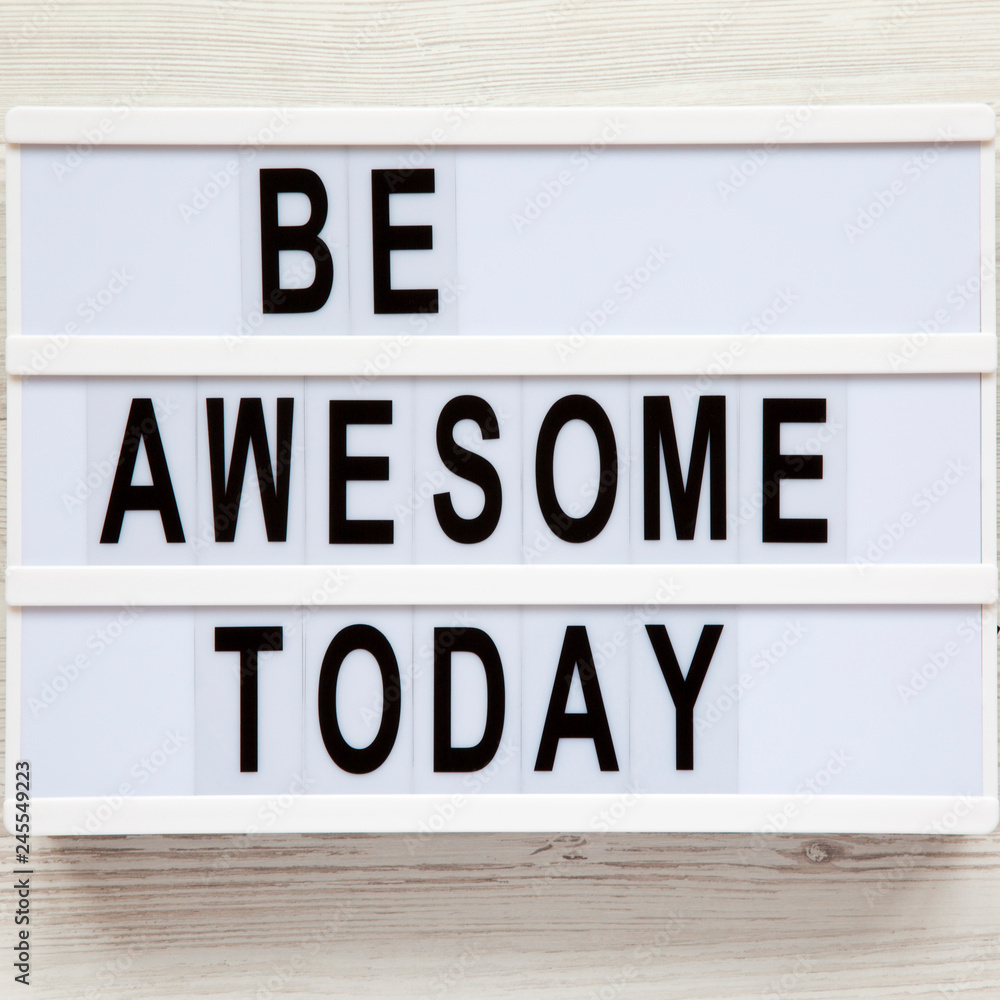 'Be awesome today' word on modern board over white wooden surface, from above. Flat lay, overhead, top view.