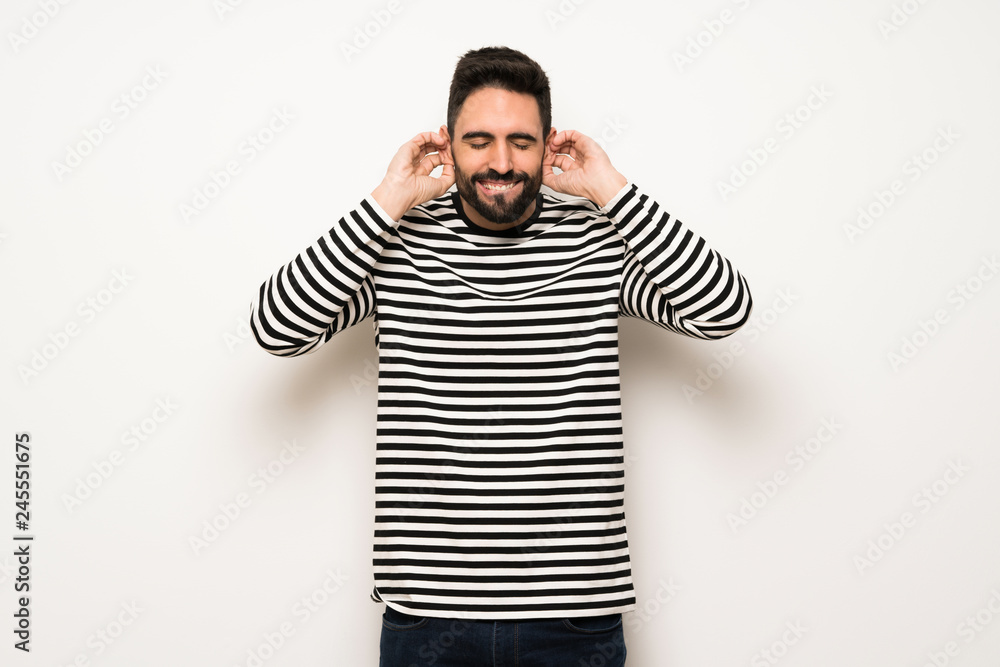 handsome man with striped shirt covering ears with hands. Frustrated expression handsome man with striped shirt covering ears with hands. Frustrated expression