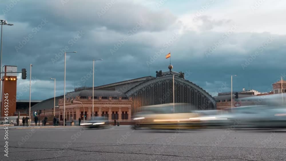 Timelapse traffic rush hour in Emperor Charles V square, with Madrid Atocha railway station on the background in Madrid, Spain. Timelapse traffic rush hour in Emperor Charles V square, with Madrid Atocha railway station on the background in Madrid, Spain.