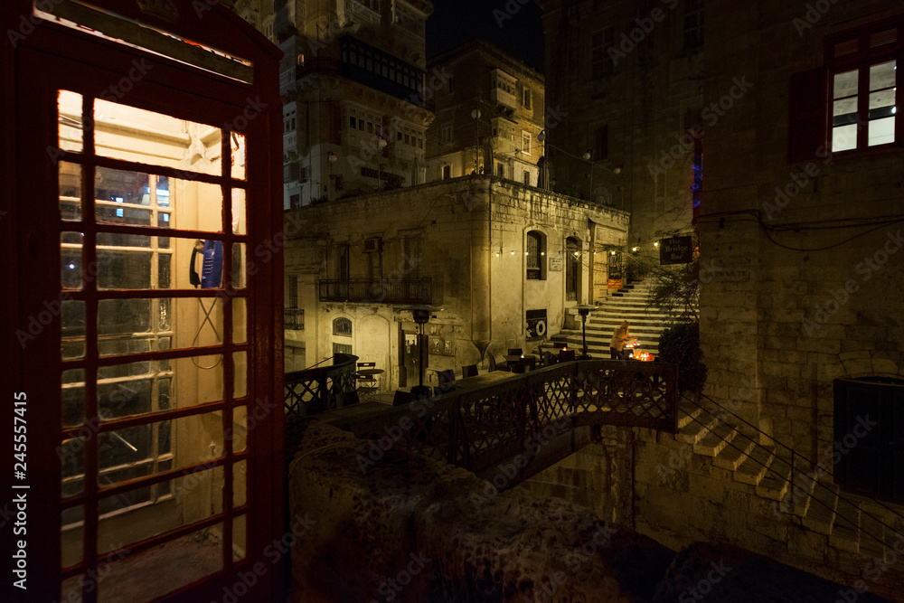 Walking through the night Malta. Maltese style. Old phone booth.