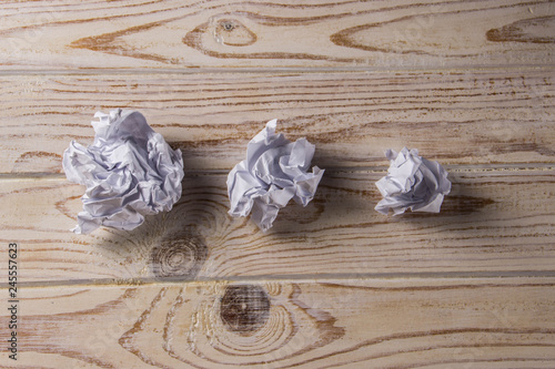 Crumpled white paper on a wooden table