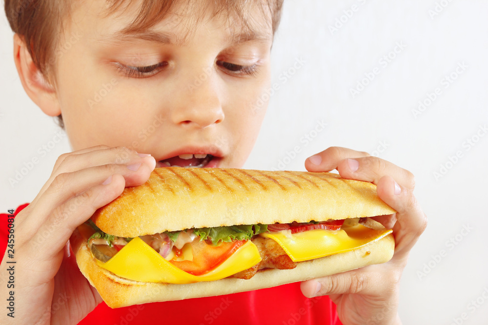 Funny boy in red with a tasty cheeseburger on a white background close up
