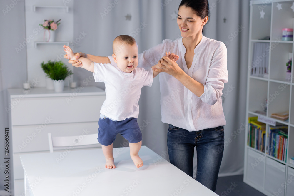 Fototapeta premium baby is learning to take the first steps