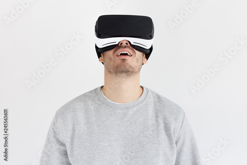 Studio portrait of astonished young man in virtual reality glasses. VR concept © Damir Khabirov