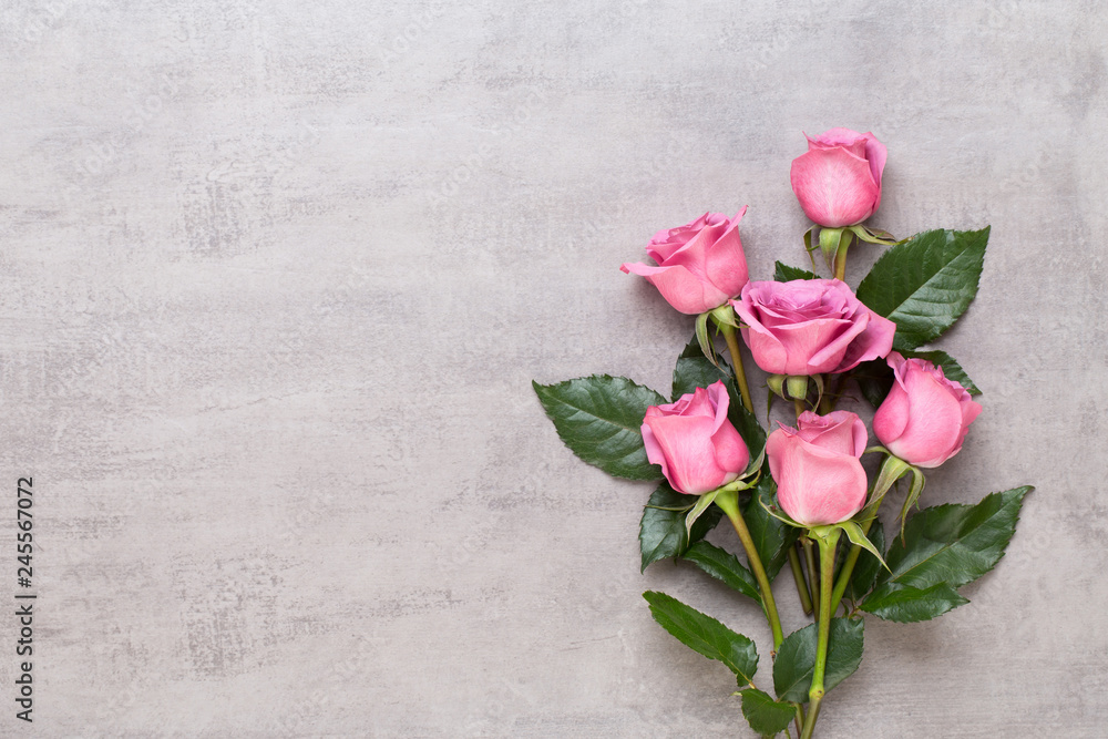 Fototapeta premium Kompozycja walentynki kwiaty. Rama wykonana z różowej róży na szarym tle. Leżał na płasko, widok z góry, miejsce na kopię.