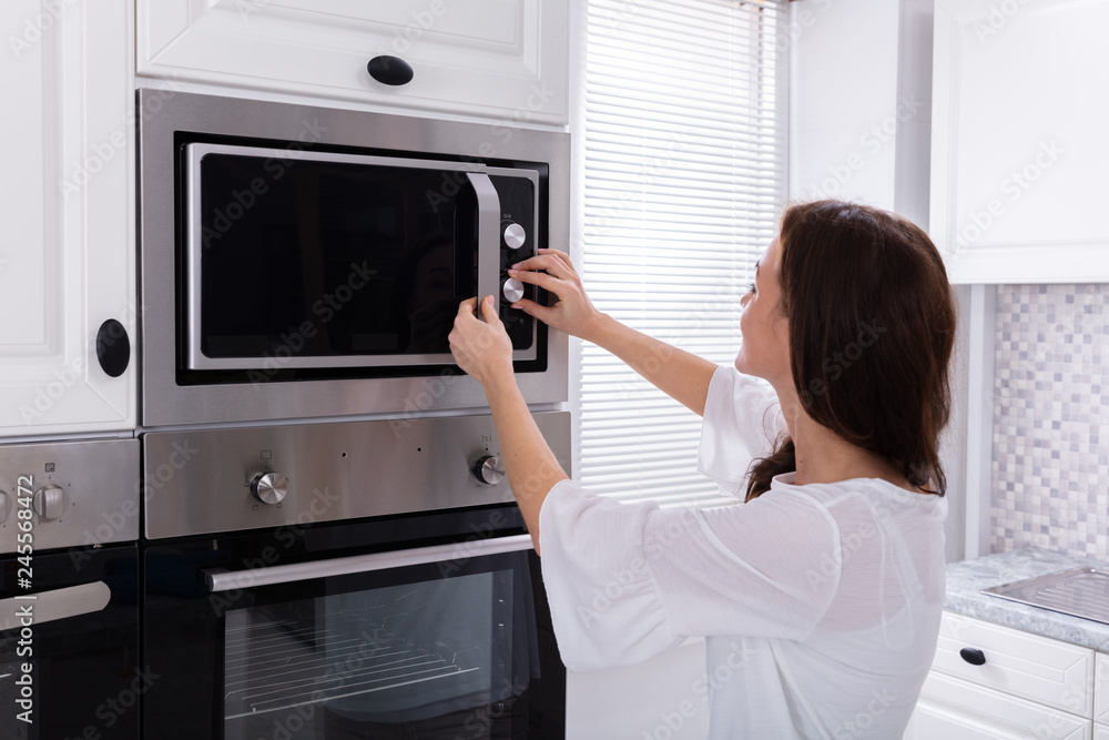 Woman Using Microwave Oven Woman Using Microwave Oven
