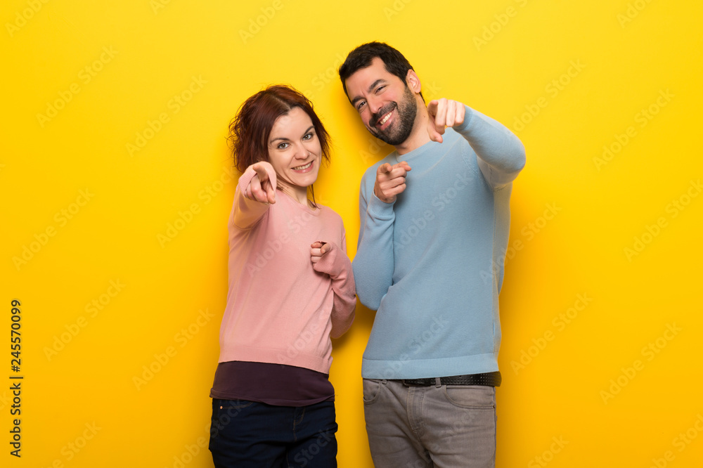 Couple in valentine day points finger at you with a confident expression Couple in valentine day points finger at you with a confident expression