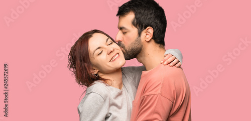 Couple in valentine day kissing over isolated pink background