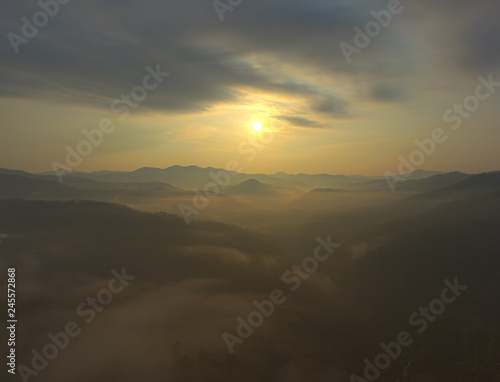 Fantastic dreamy sunrise on top of rocky mountain with view into misty valley.Mountain view.Foggy mountain.Dreamy forrest. Sunrise clouds. Forest hill.Autumn mist.Misty peaks.Foggy landscape. Hill top