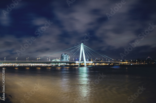 Famous landmark bridge construction Severin Bridge Severinsbrücke near Rheinauhafen at colorful night with long exposure cloud. Köln, Cologne in Germany