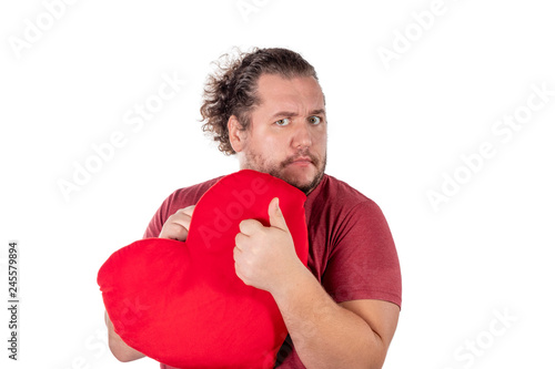 A studio shot of a fat man holding a red heart shaped pillow isolated on white background