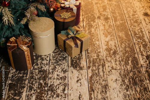  Gift boxes with bows under the Christmas tree on a wooden background. Old village floor  beautiful christmas background