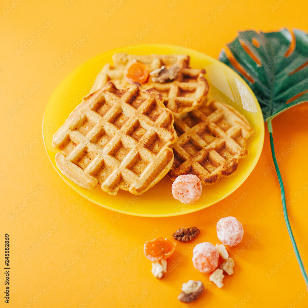 Traditional belgian waffles with fresh fruit and nuts. Orange. Traditional belgian waffles with fresh fruit and nuts. Orange.