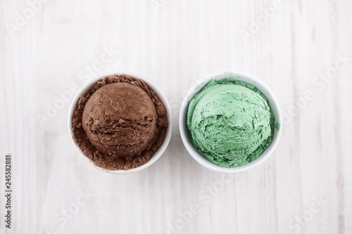 chocolate and pistachio ice cream with bowl on wooden background