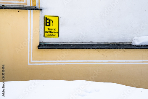 Schild an Hauswand mahnt zur Vorsicht vor Dachlawinen