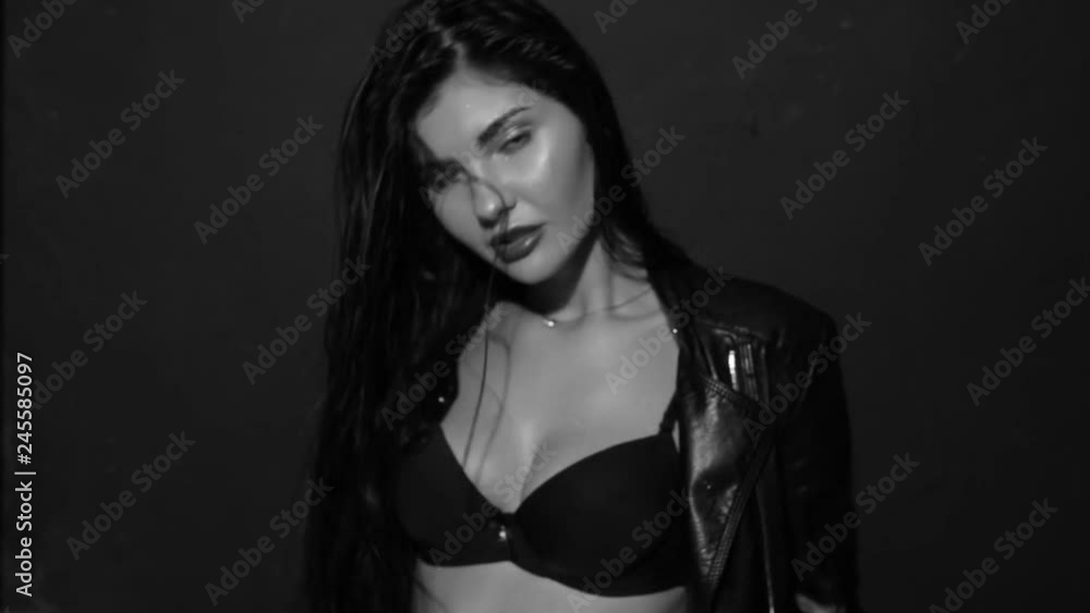 Fashionable girl posing in jeans in the studio. Black and white video. Fashionable girl posing in jeans in the studio. Black and white video.