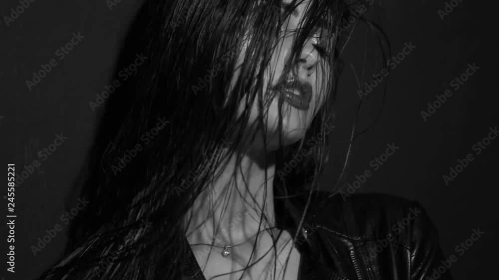 Fashionable girl posing in jeans in the studio. Black and white video. Fashionable girl posing in jeans in the studio. Black and white video.