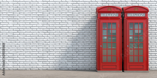 Red phone booth on brick wall background. London, british and english symbol. photo