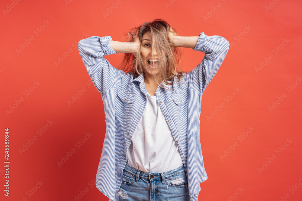 Funny, cute girl having fun while playing with hair isolated on a red background Funny, cute girl having fun while playing with hair isolated on a red background