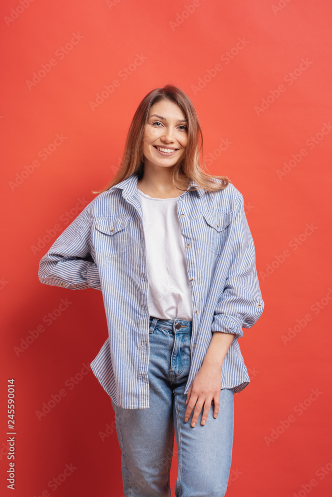 Pretty female model posing with a smiling face expression on red background