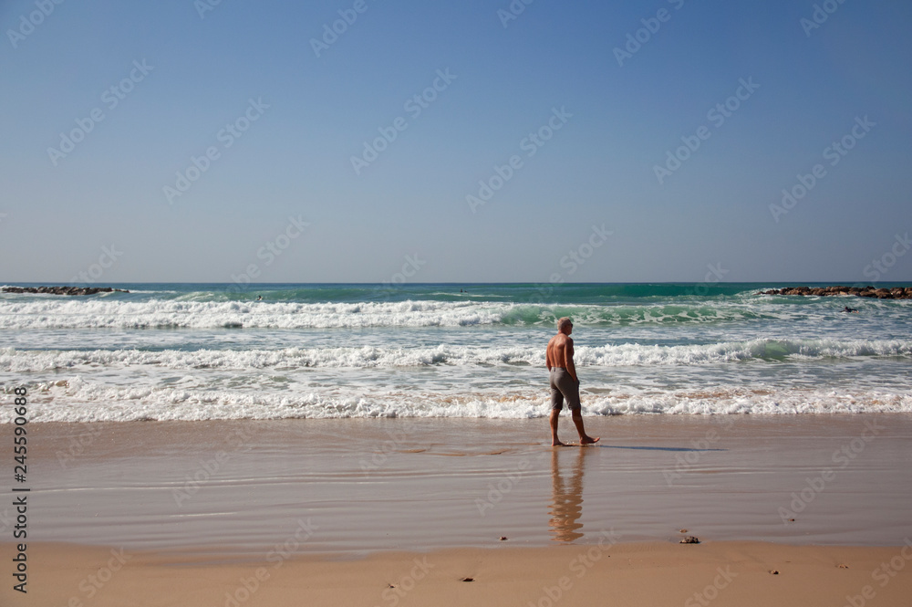 Handsome man resting on the beach against the sea landscape Handsome man resting on the beach against the sea landscape