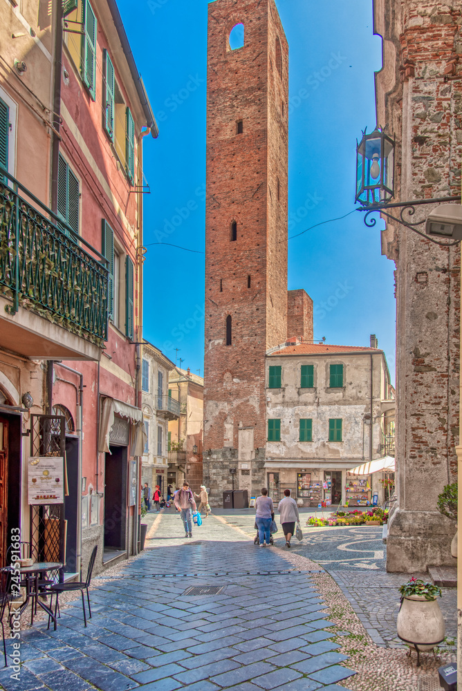 Old medieval tower in a square in Noli, Italy