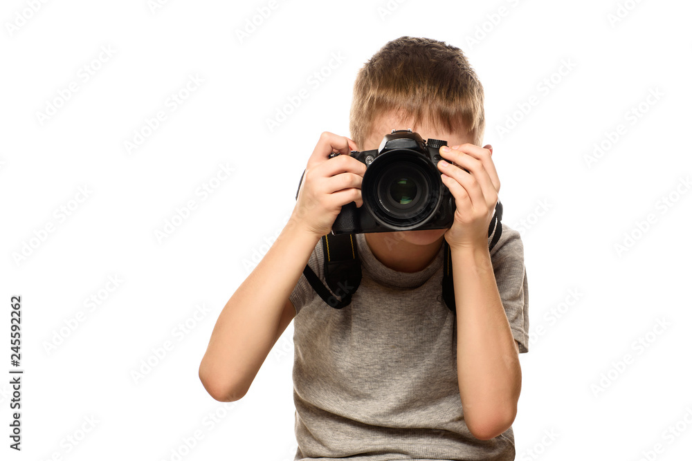 Boy takes pictures on the camera. Portrait. Isolate on white background Boy takes pictures on the camera. Portrait. Isolate on white background