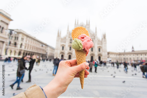 Travel, Italy, gelato and holidays concept - Ice cream in front of Milan Cathedral Duomo