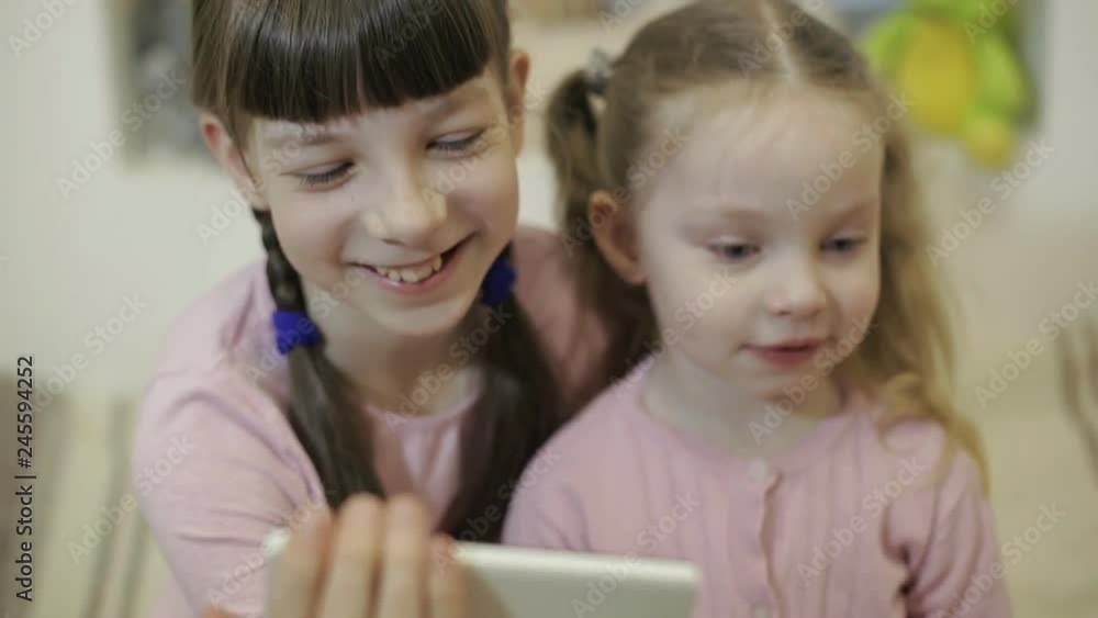 two little girls having video chat using smartphone with their friends two little girls having video chat using smartphone with their friends