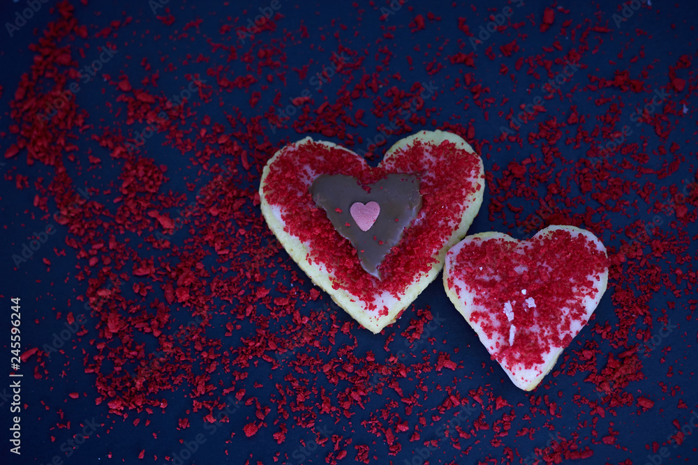 Heart-shaped shortbread cookies decorated for Valentine's Day on a black background. Delicious homemade natural organic pastry with love. Love concept.  
