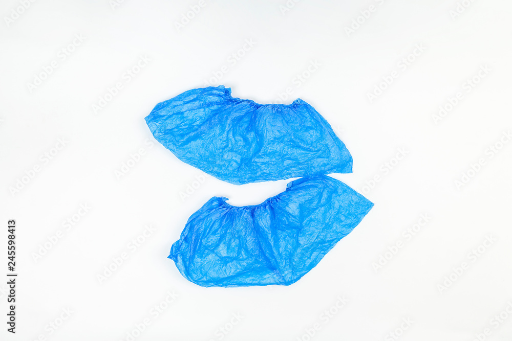 Blue medical shoe covers on white background. Cleanliness in medical institutions. Top view