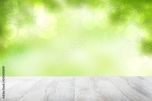 Empty table top summer background. Empty rustic wooden bright table top in front of beautiful abstract green summer or spring background. Template for product display montage. Space.