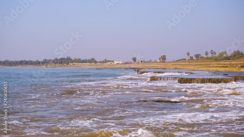 Zoom shot of waves dashing against rocks in the middle of the sea at Nagaon beach, Diu, Gujarat, India photo