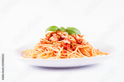 Spaghetti bolognese with melted parmesan cheese decorated with basil on a white background