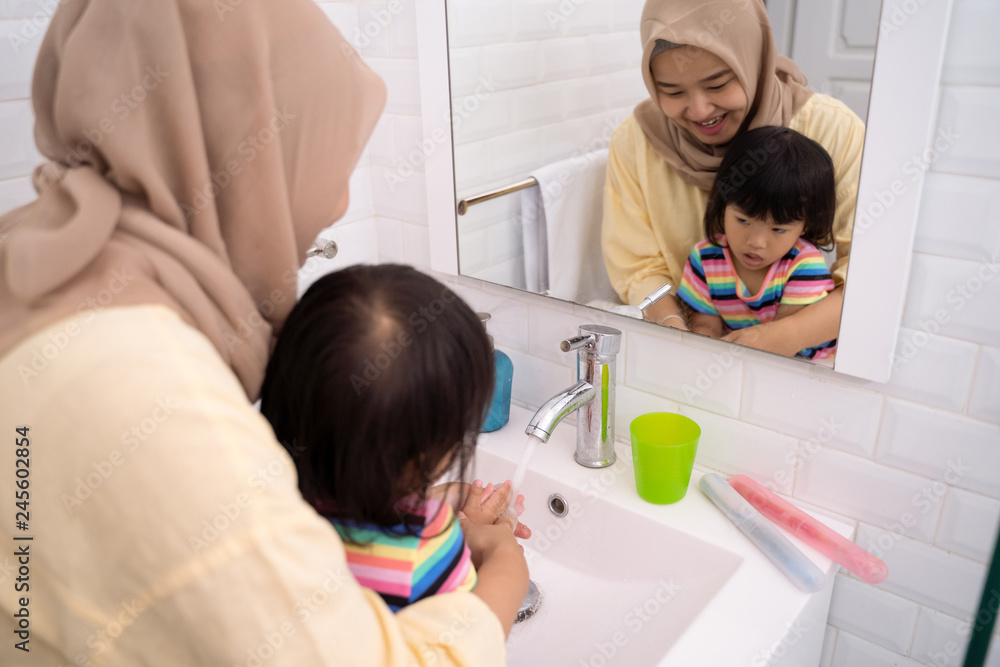 mom help her kid to wash her hands mom help her kid to wash her hands