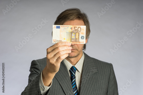 Businessman hand holding money, euro bill. Hands holding fifty euros in front of face