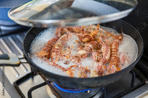boiling a pot of mantis shrimps in the kitchen with the lid up